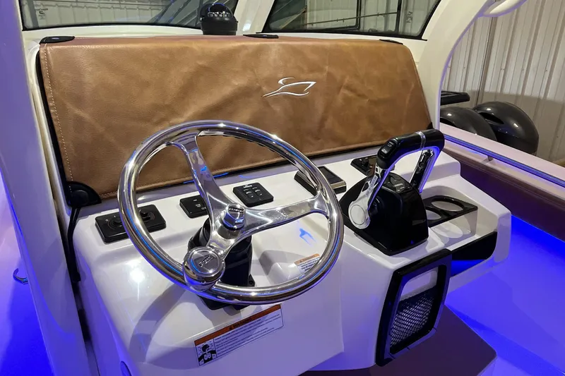 Slide: The Image of 2021 Scout 305 LXF boat helm with steering wheel and controls. - 28