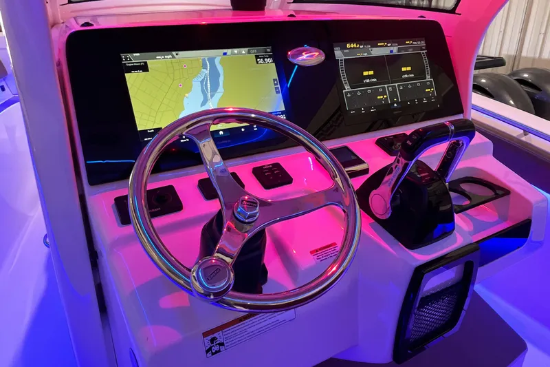 Slide: The Image of 2021 Scout 305 LXF boat dashboard with navigation screens and steering wheel. - 29