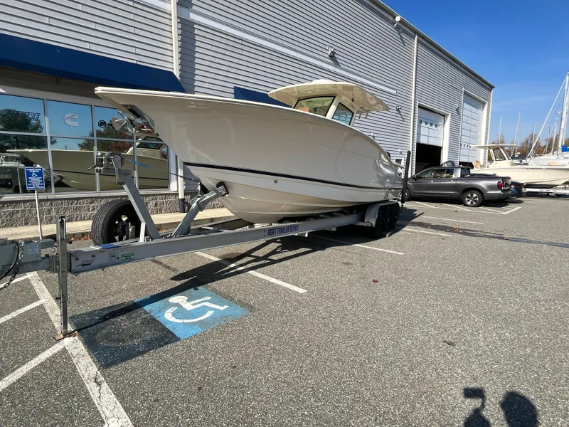 Slide: The Image of 2021 Scout 305 LXF boat on trailer in parking lot. - 3
