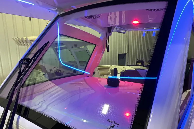 Slide: The Image of 2021 Scout 305 LXF boat interior with illuminated dashboard and windshield. - 37