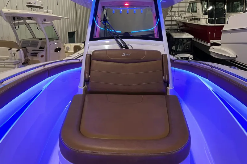 Slide: The Image of 2021 Scout 305 LXF boat interior with blue LED lighting and brown seating. - 38