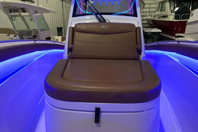 Slide: The Image of 2021 Scout 305 LXF boat interior with brown seating and blue LED lighting. - 39