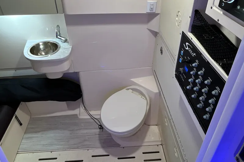 Slide: The Image of 2021 Scout 305 LXF boat interior with sink, toilet, and control panel. - 44