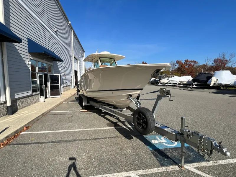Slide: The Image of 2021 Scout 305 LXF boat on trailer in parking lot. - 6