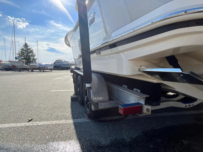 Slide: The Image of 2021 Scout 305 LXF boat on trailer in sunny marina parking lot. - 7
