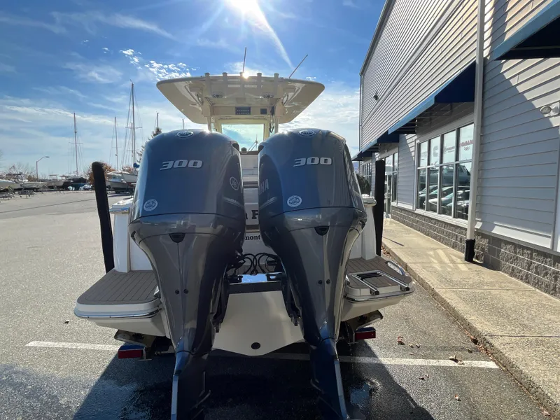 Slide: The Image of 2021 Scout 305 LXF boat with twin 300 horsepower engines, parked outdoors. - 8