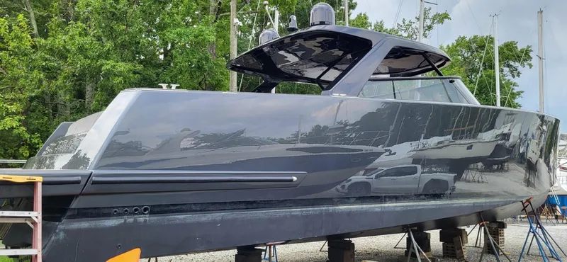 Slide: The Image of Sleek 2023 VanDutch 56 yacht roof with antennas, surrounded by lush greenery. - 6