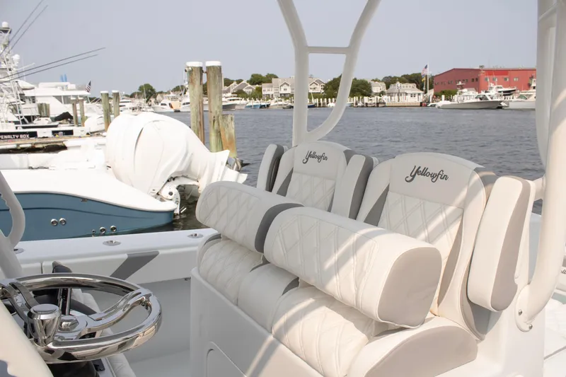 Slide: The Image of 2025 Yellowfin 32 Offshore boat interior with luxurious seating at a marina. - 15