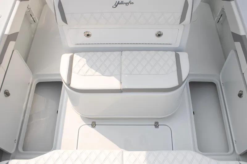 Slide: The Image of 2025 Yellowfin 32 Offshore boat interior with white cushioned seating and storage compartments. - 23