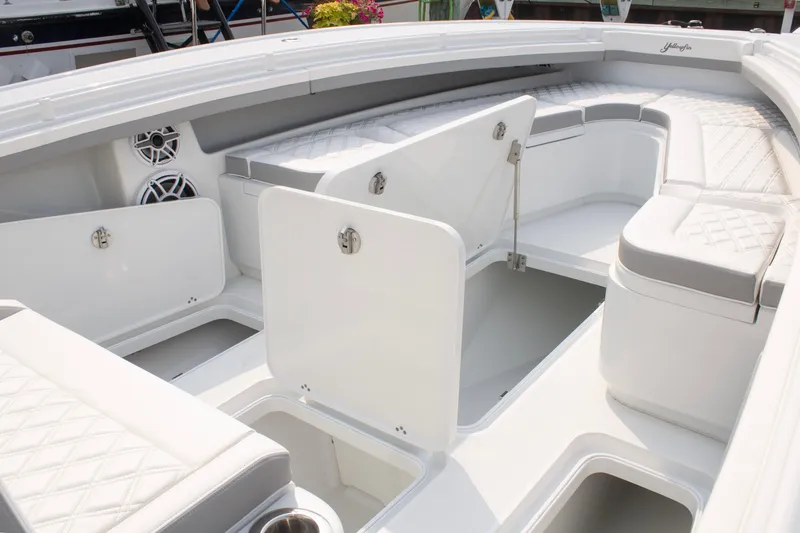 Slide: The Image of 2025 Yellowfin 32 Offshore boat interior with open storage compartments and cushioned seating. - 8