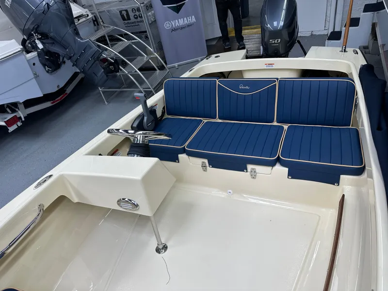 Slide: The Image of 2025 Rossiter 14 boat interior with blue cushioned seating and Yamaha outboard motor. - 11