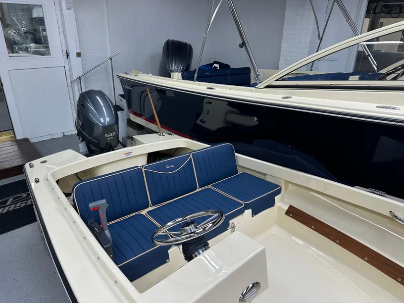 Slide: The Image of 2025 Rossiter 14 boat with blue seating and outboard motor in showroom. - 7