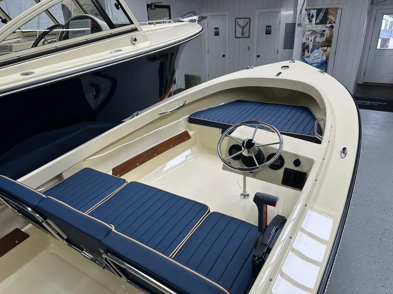 Slide: The Image of 2025 Rossiter 14 boat interior with blue seating and steering wheel in showroom. - 9
