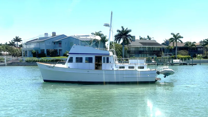 Slide: The Image of 1972 Bristol 42 Offshore Trawler on calm water near waterfront homes. - 0