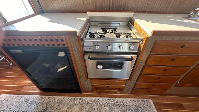 Slide: The Image of 1972 Bristol 42 Offshore Trawler kitchen with stove, fridge, and wooden cabinetry. - 10