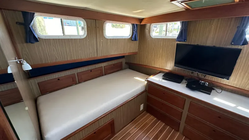 Slide: The Image of Interior of 1972 Bristol 42 Offshore Trawler with bed, TV, and wooden cabinetry. - 19