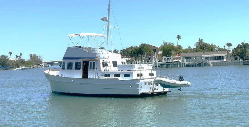 Slide: The Image of 1972 Bristol 42 Offshore Trawler on calm water near shoreline homes. - 2