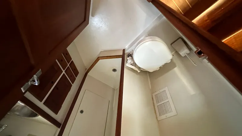 Slide: The Image of Interior of 1972 Bristol 42 Offshore Trawler bathroom with toilet and wooden cabinetry. - 23