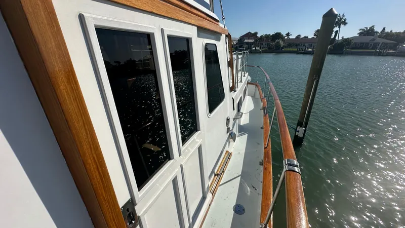 Slide: The Image of 1972 Bristol 42 Offshore Trawler on calm water, showcasing wooden railings and windows. - 39
