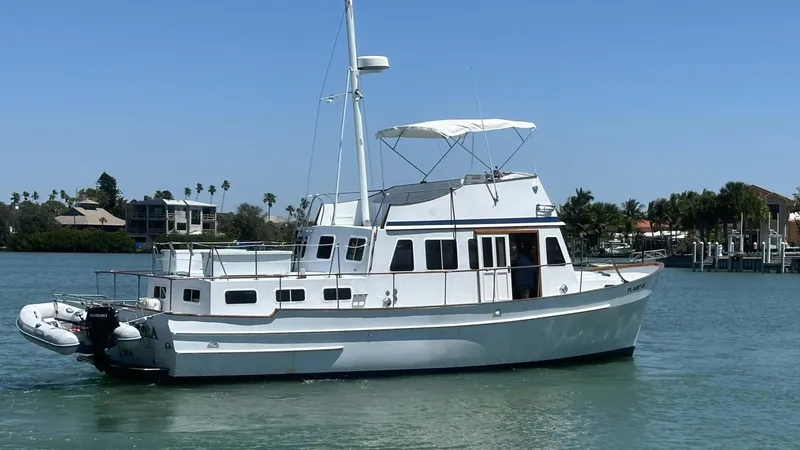 Slide: The Image of 1972 Bristol 42 Offshore Trawler on calm water, featuring classic design and white exterior. - 44