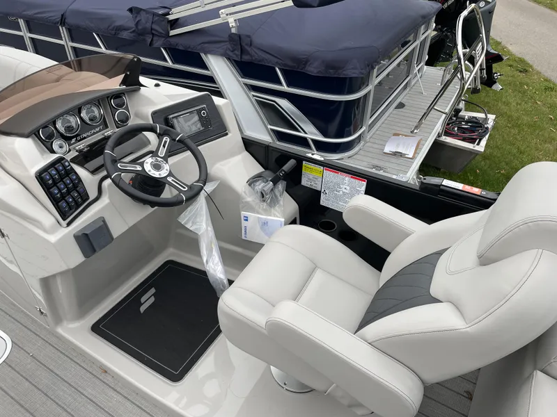 Slide: The Image of 2024 Starcraft SLS 5 boat cockpit with steering wheel and comfortable seating. - 9