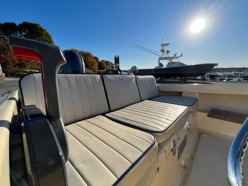 Slide: The Image of 2016 Rossiter Shoreline 14 boat interior with cushioned seating under bright sun. - 13