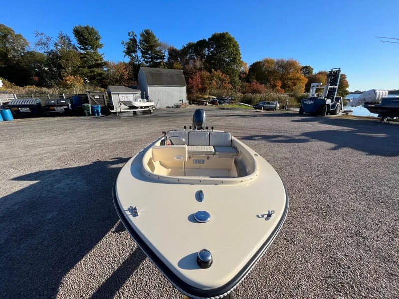 Slide: The Image of 2016 Rossiter Shoreline 14 boat on gravel lot with trees and clear sky. - 15