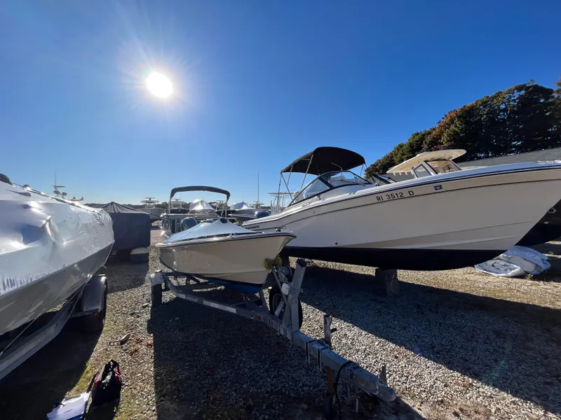 Slide: The Image of 2016 Rossiter Shoreline 14 boat on trailer under bright sun. - 17
