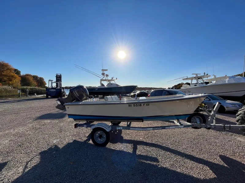 Slide: The Image of 2016 Rossiter Shoreline 14 boat on trailer under bright sun in marina. - 4