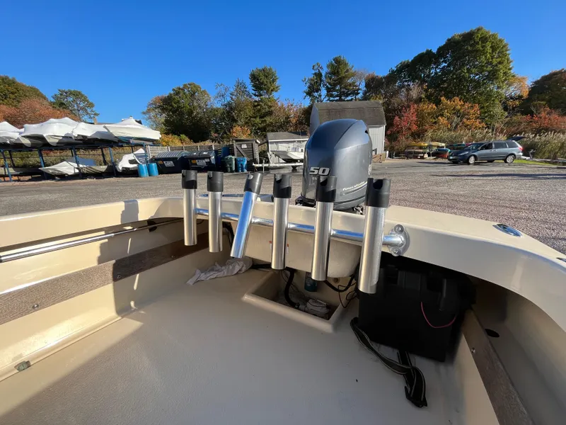Slide: The Image of 2016 Rossiter Shoreline 14 boat with motor and rod holders in a sunny outdoor setting. - 7