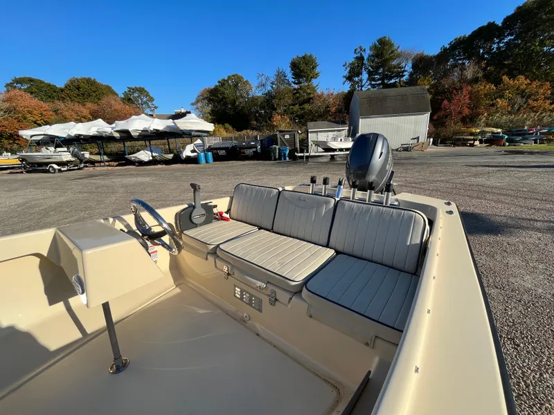 Slide: The Image of 2016 Rossiter Shoreline 14 boat interior with seating and controls, parked outdoors. - 8