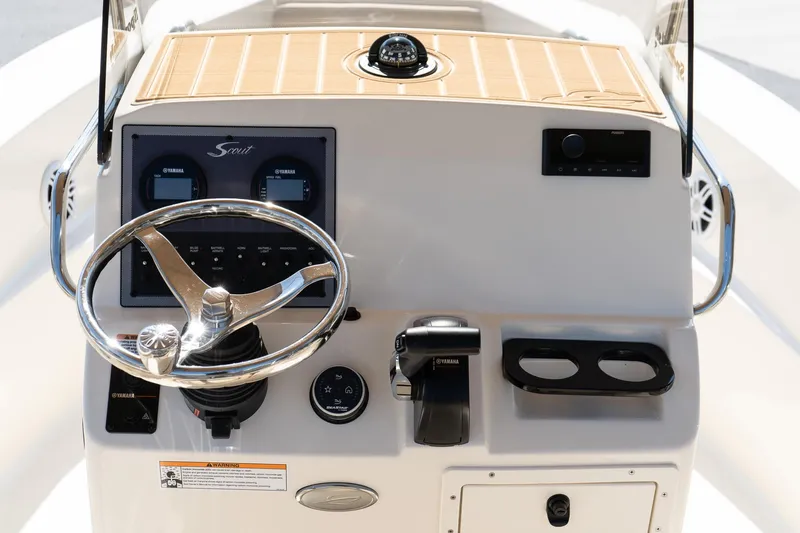 Slide: The Image of 2025 Scout 195 Sportfish boat dashboard with steering wheel and controls. - 10