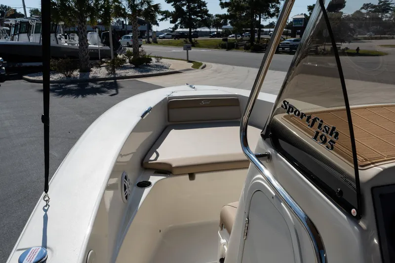 Slide: The Image of 2025 Scout 195 Sportfish boat, sleek design, spacious deck, parked outdoors. - 20