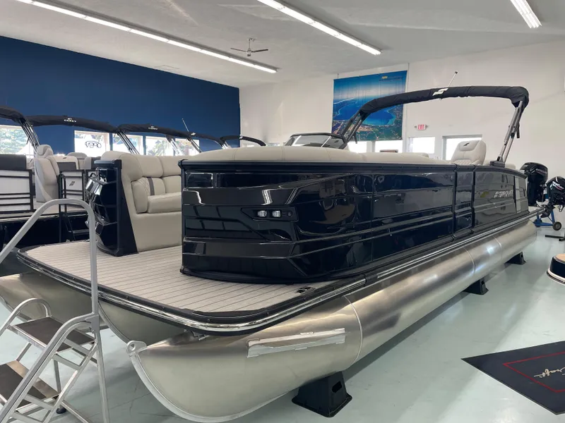 The Image of 2025 Starcraft RX 25 Q DC pontoon boat in showroom, sleek black design. - 0