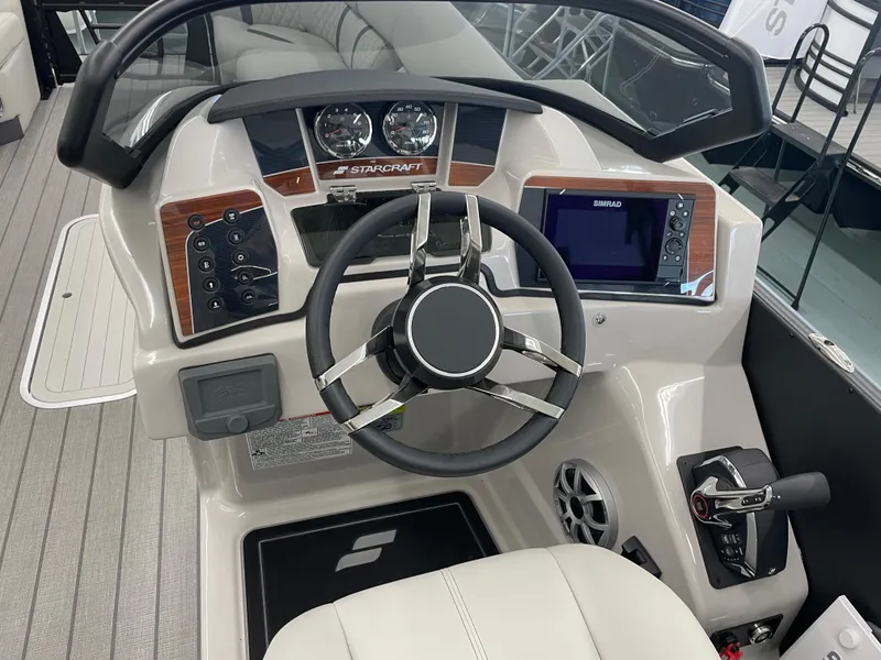 Slide: The Image of 2025 Starcraft RX 25 Q DC boat dashboard with steering wheel and control panel. - 13