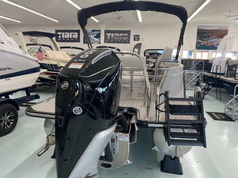 Slide: The Image of 2025 Starcraft RX 25 Q DC boat in showroom, featuring powerful outboard motor. - 2