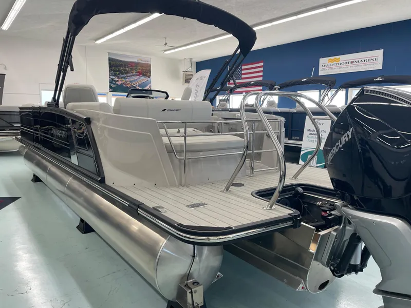 Slide: The Image of 2025 Starcraft RX 25 Q DC pontoon boat in showroom, featuring sleek design and powerful engine. - 6