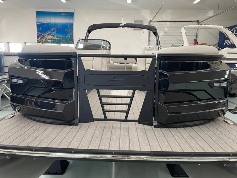 Slide: The Image of 2025 Starcraft RX 25 Q DC pontoon boat in showroom, sleek black design. - 7