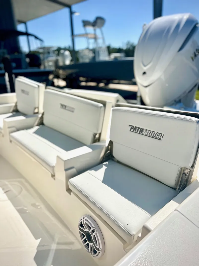 Slide: The Image of 2025 Pathfinder 2600 TRS boat interior with white seating and speaker. - 3