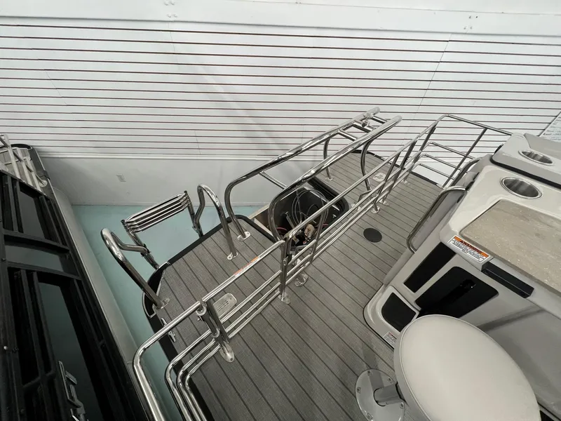 Slide: The Image of 2023 Starcraft CX 25 DL BAR boat deck with stainless steel railings and seating area. - 14