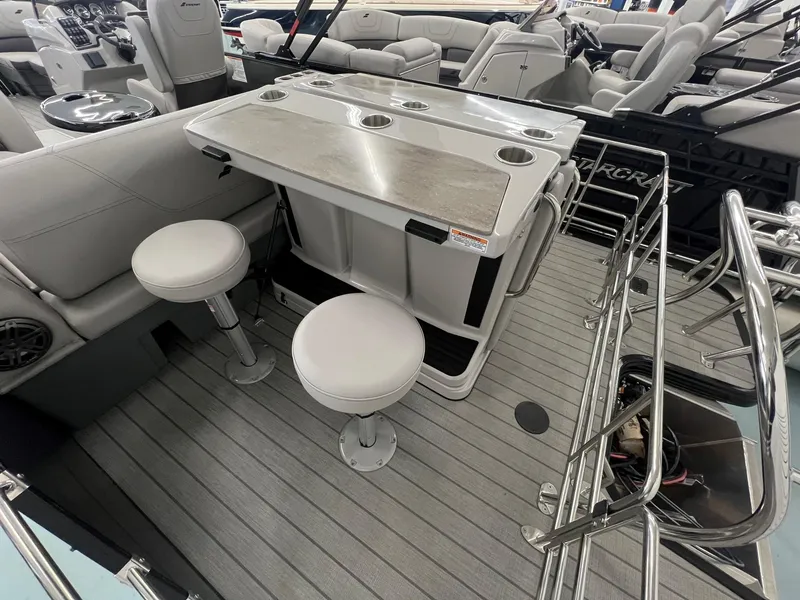 Slide: The Image of 2023 Starcraft CX 25 DL BAR boat interior with bar stools and table. - 15