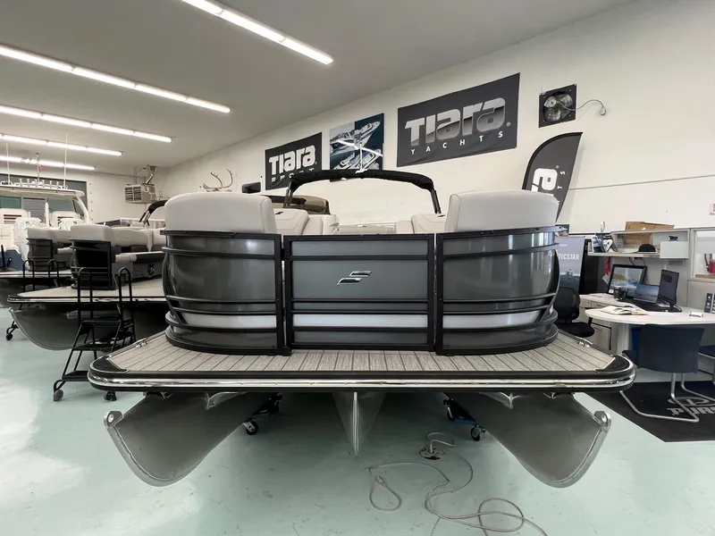 Slide: The Image of 2023 Starcraft CX 25 DL BAR pontoon boat in showroom, front view. - 2