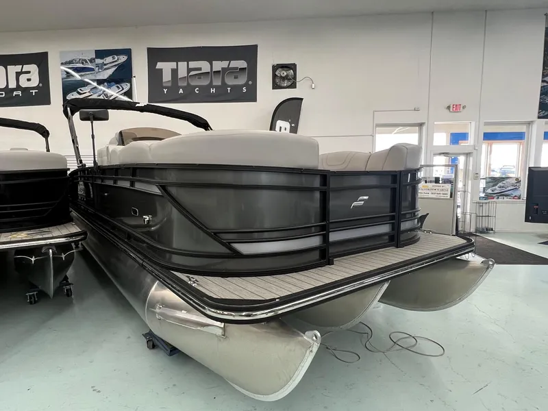 Slide: The Image of 2023 Starcraft CX 25 DL BAR pontoon boat in showroom, featuring sleek design and modern amenities. - 3