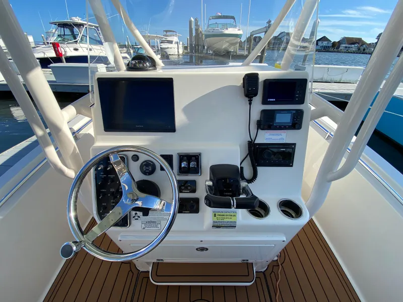 Slide: The Image of 2018 Cobia 237 CC boat console with steering wheel and navigation equipment. - 12