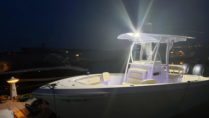 Slide: The Image of 2018 Cobia 237 CC boat illuminated at night on a dock. - 16