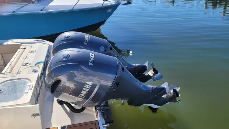 Slide: The Image of 2018 Cobia 237 CC with twin Yamaha 150 outboard motors on calm water. - 17