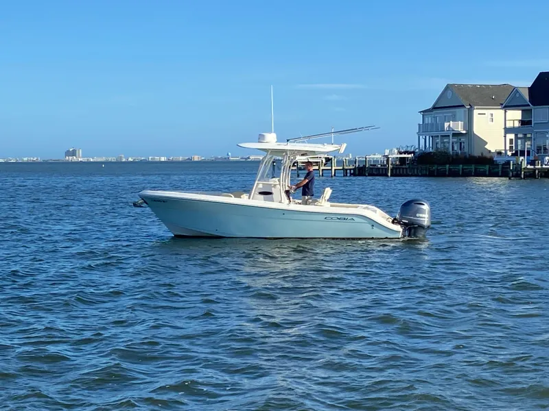 Slide: The Image of 2018 Cobia 237 CC boat on calm water near waterfront homes. - 4