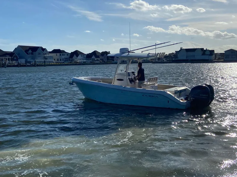 Slide: The Image of 2018 Cobia 237 CC boat on water near coastal homes. - 8