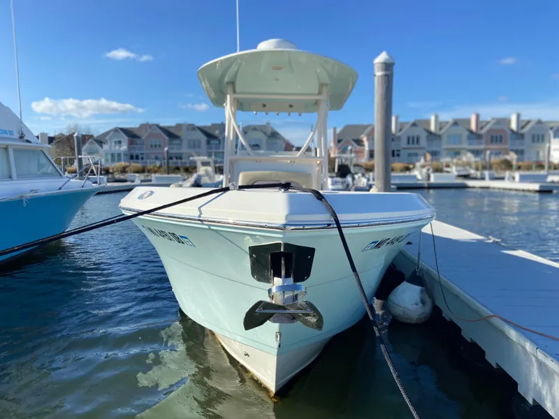 Slide: The Image of 2018 Cobia 237 CC boat docked at marina with waterfront homes in background. - 9