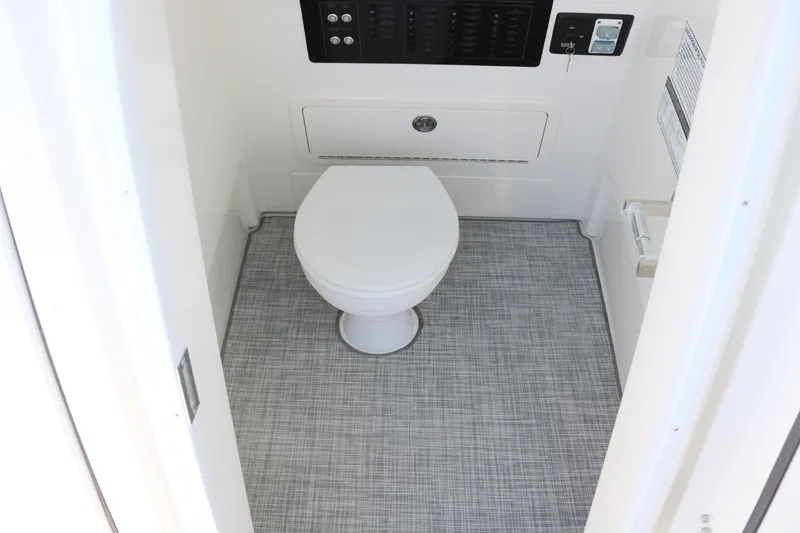 Slide: The Image of 2025 World Cat 260 CC-X boat interior bathroom with modern toilet and control panel. - 10